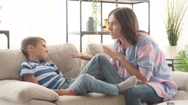 母亲和儿子在家里的沙发上聊天视频下载