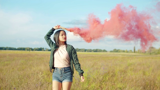亚洲漂亮女人与红色烟雾弹的性质视频素材