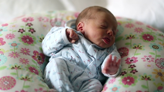 新生婴儿在生命的第一个星期里睡着，梦见伸展身体视频素材
