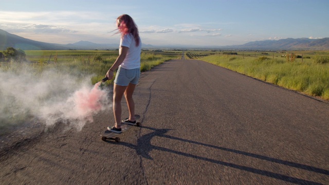 一个粉色头发的少女在路上玩滑板视频素材