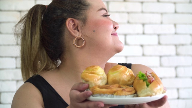 泰国胖女人的脸是幸福的，闻到了最爱的甜面包视频素材