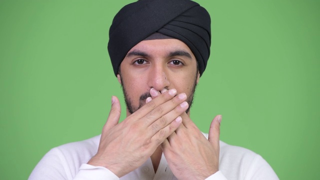 年轻英俊的长着胡子的印度男人的脸显示出不讲邪恶的概念视频素材