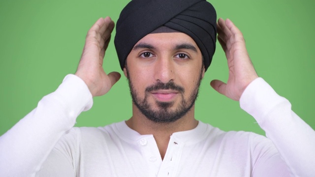 年轻英俊的长着胡子的印度男人的脸显示出听不到邪恶的概念视频素材