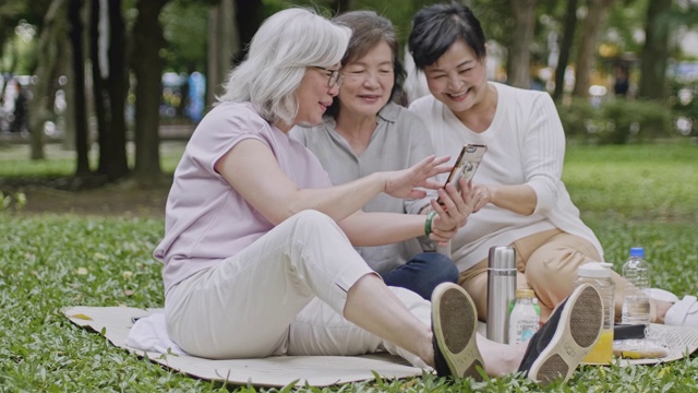 看着智能手机笑的台湾大妈视频素材