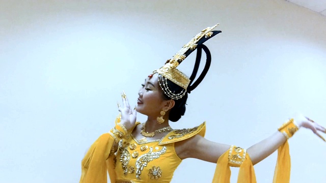 美丽的亚洲女子穿着中国传统的黄色服装跳舞视频素材