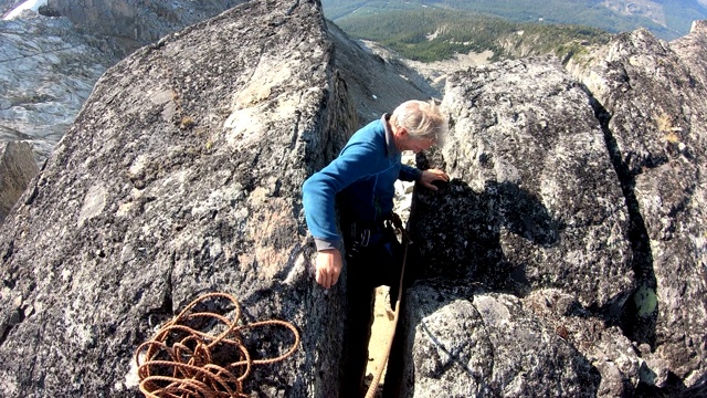一名登山者准备帮助同伴穿过高山裂缝视频下载
