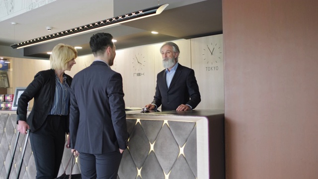 成熟的酒店接待员与男客人握手视频下载