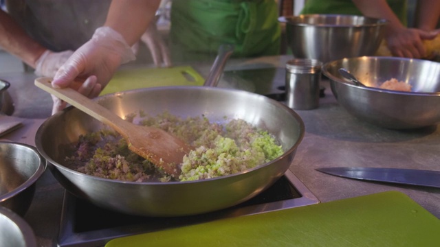 厨师用橄榄油在平底锅中搅拌洋葱丁和芹菜丁视频下载