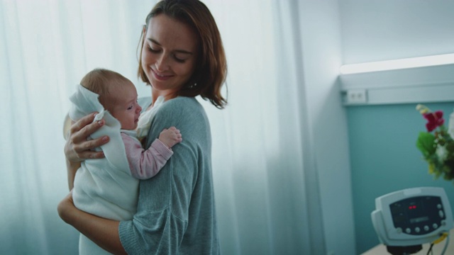 美丽的母亲抱着婴儿在急诊室视频下载