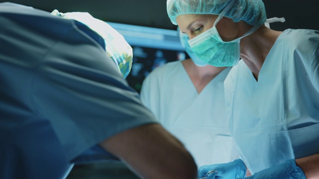 女护士在手术中协助外科医生视频下载