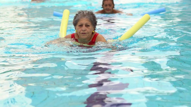 老年妇女在游泳池里锻炼身体视频素材