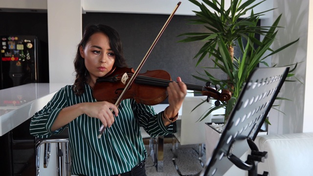 女人在家里练习小提琴视频素材