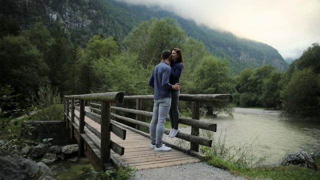 年轻夫妇享受在河上的老木桥在自然的质量度过的时间视频素材
