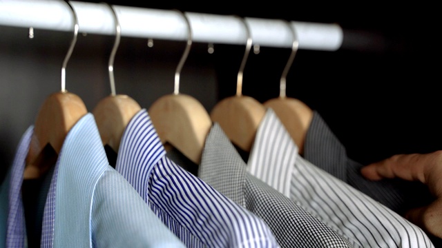 一名商人会在你去上班或晚上外出之前在你的衣柜里选择衬衫。视频素材