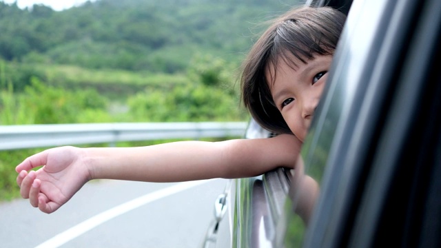 这个小孩坐着汽车，在旅游气氛中感到神清气爽。视频下载