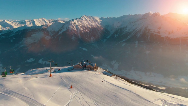 在一个阳光明媚的下午，空中直升机拍摄的平静的乡村山区景观，白雪覆盖的山峰和奥地利阿尔卑斯山的滑雪胜地景观视频素材