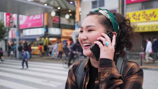 在东京，年轻的蒙古女背包客在用智能手机视频素材