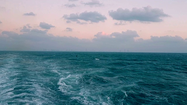 大船后面跟着巨浪。船上引擎的追踪。游船航行在蓝色的海洋上。船尾的波浪。视频素材