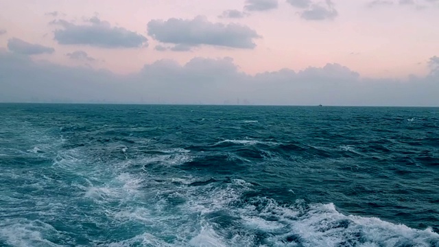 大船后面跟着巨浪。船上引擎的追踪。游船航行在蓝色的海洋上。船尾的波浪。视频素材