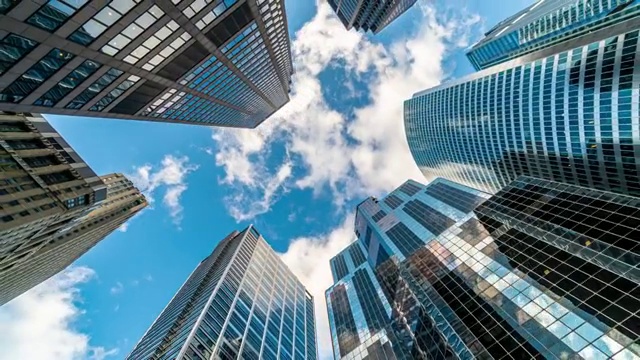 4K时间流逝芝加哥市中心摩天大楼的上升角度与高楼之间的云反射，伊利诺伊州，美国，商业和透视概念视频素材