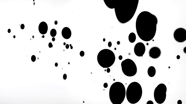 特写和慢动作的木炭黑色液体到水和板条箱一排大大小小的球，白色的背景视频下载