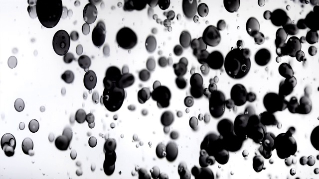 特写和慢动作的各种大小木炭色的气泡在水中跳跃，白色的背景视频素材
