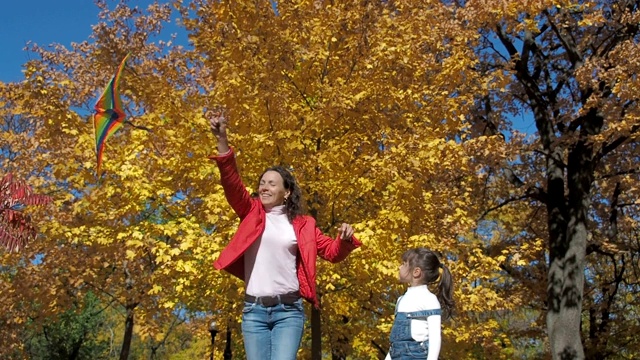 一家人在秋天的公园放风筝。视频素材
