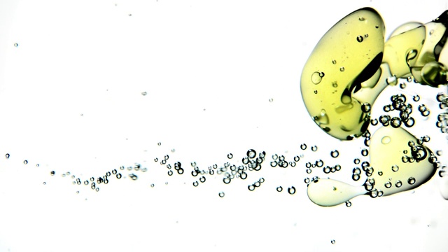 近距离和缓慢的运动弹跳黄色气泡移动从右侧与小水泡在白色背景视频素材