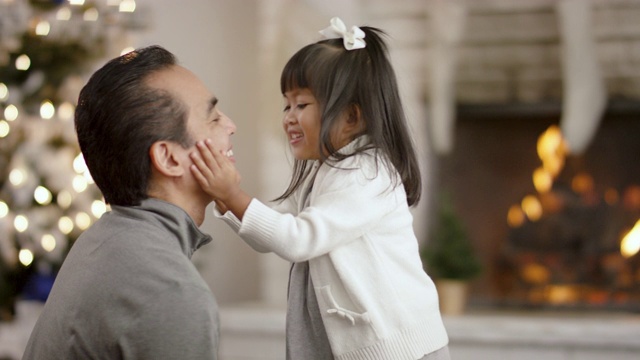 一位亚洲父亲和女儿在圣诞树旁共度时光视频购买