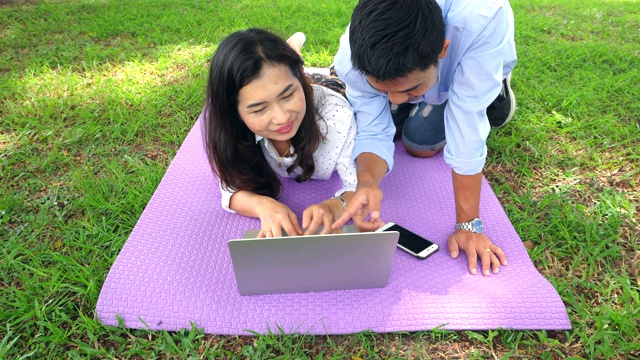 年轻夫妇在公园里用信用卡支付网上购物视频素材