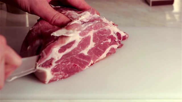 厨师把新鲜猪肉切成牛排。视频下载
