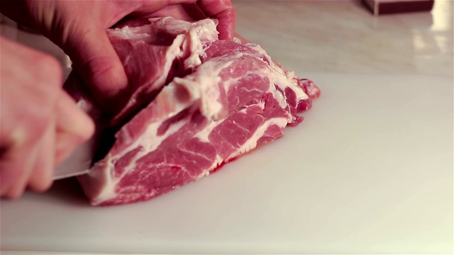 厨师把新鲜的生肉切成牛排。视频下载