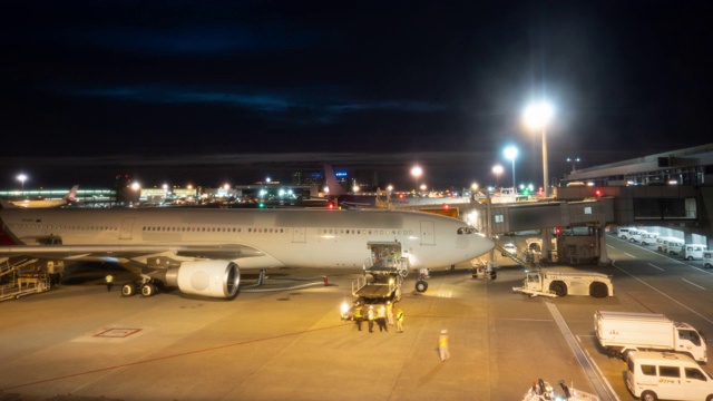 延时:夜间将行李装载到飞机上的货车。放大照片视频素材