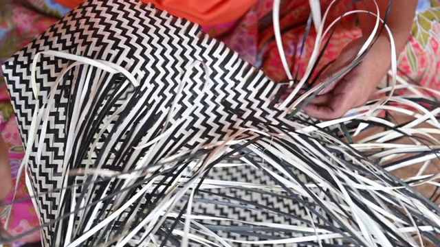特写的妇女编织一个干叶编织篮子，篮子的手工工艺生产视频下载