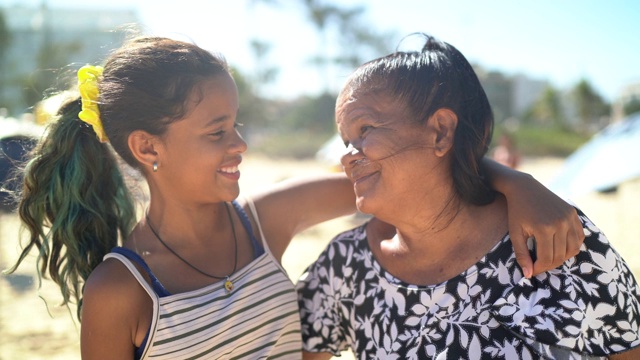 孙女和祖母在海滩上微笑拥抱视频下载
