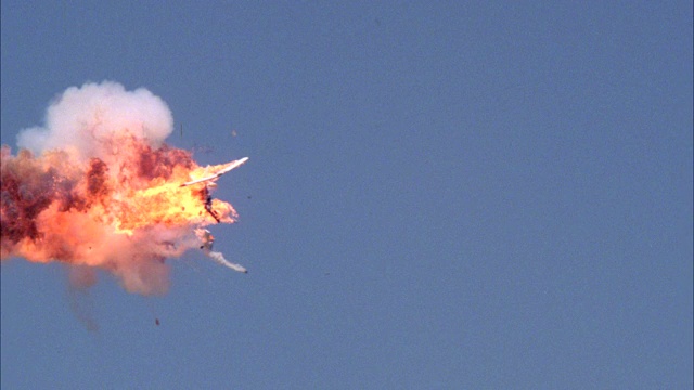 从左到右的塞斯纳单引擎飞机飞行。飞机爆炸。火焰、火、烟和碎片从天而降。视频素材