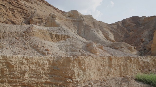 慢动作:蓝色运动球沿着一个悬崖面在一个荒凉的阳光沙漠-死海，以色列视频下载