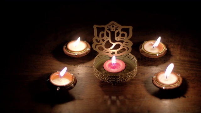 影子和光跳舞，在甘尼萨雕刻的木桌上玩反射，也甘尼帕提Vinayaka，印度万神殿中最著名和最崇拜的神之一，特别是在排灯节期间视频素材