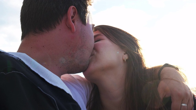 肖像男友和女友当他们亲吻特写背景蓝色4K。视频下载