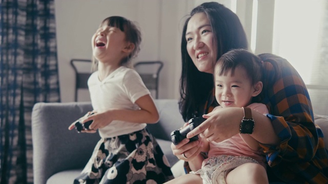 亚洲母亲和女儿玩电子游戏(慢动作)视频素材