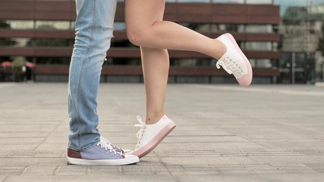 期待已久的相爱的年轻人的相遇。一对年轻的情侣在户外接吻，近距离的双腿和鞋子。爱情和关系概念视频下载
