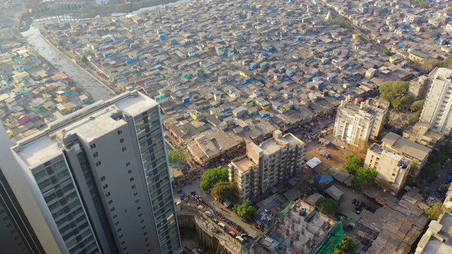 航拍图:印度孟买，贫民窟和排水系统旁的现代摩天大楼视频下载