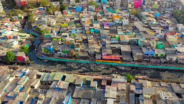 航拍:印度孟买，贫民窟里拥挤的房屋，旁边是现代化的住宅和大海视频下载