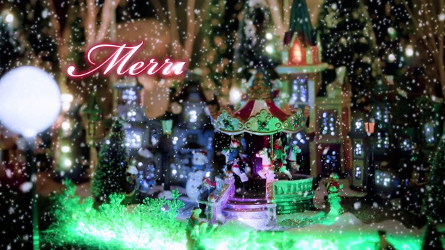 圣诞快乐文字排印设计，以红色的玩具圣诞村为场景和彩灯，装饰在雪花背景下的圣诞活动理念视频素材