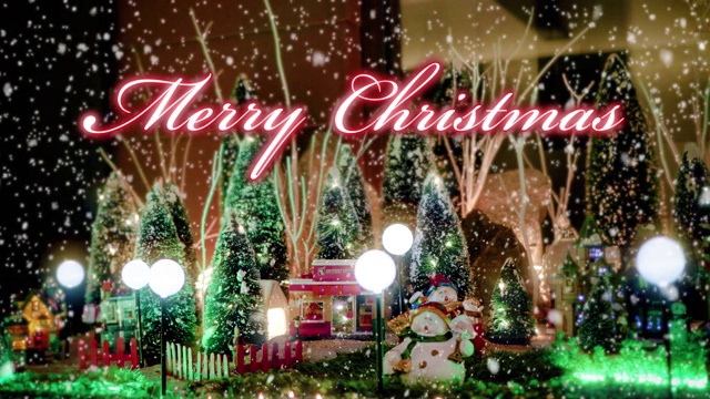 圣诞快乐文字排印设计，以红色的玩具圣诞村为场景和彩灯，装饰在雪花背景下的圣诞活动理念视频下载