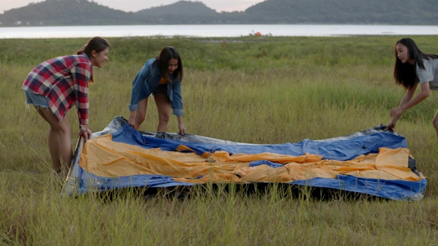 一群年轻的亚洲妇女露营搭帐篷享受一起有乐趣的夏天旅行。亚洲朋友的生活方式旅游度假时间。视频下载