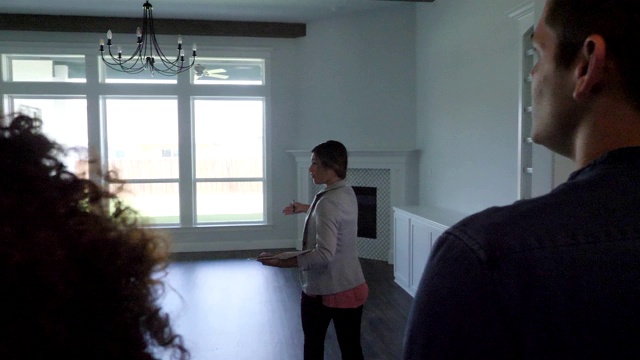 女房地产经纪人向千禧一代夫妇展示房子视频素材
