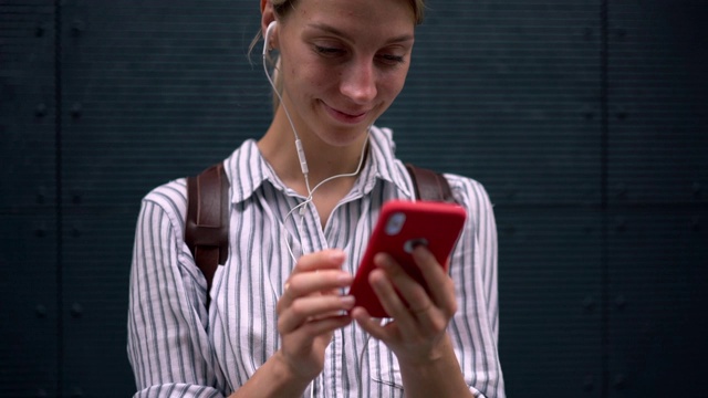 愉悦的女人一边在手机上听音乐一边在社交网络上阅读内容的慢动作效果视频素材