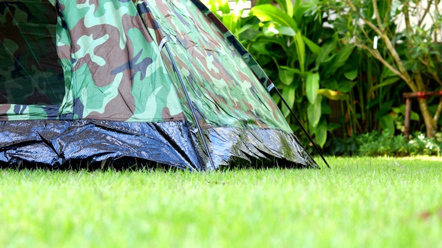 在大自然的草地上搭帐篷露营视频下载