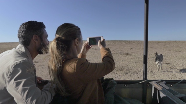 一对夫妇在南非拍摄斑马的特写照片视频素材